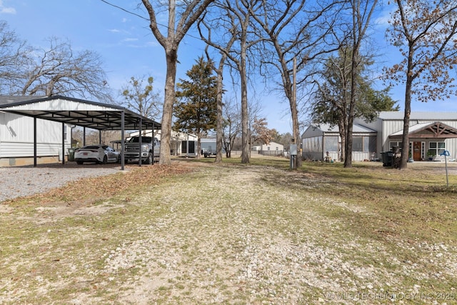 view of yard with a carport and gravel driveway