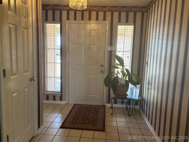 entryway featuring wallpapered walls, light tile patterned floors, and baseboards