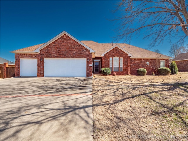 single story home with a garage, brick siding, roof with shingles, and driveway