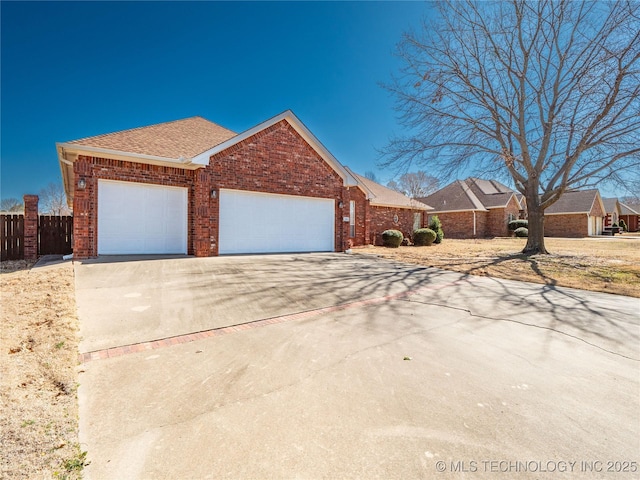 single story home featuring brick siding, driveway, a garage, and fence