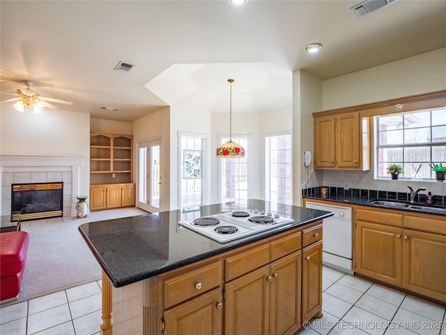 kitchen with white appliances, a fireplace, visible vents, and a sink