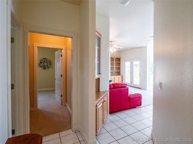 hallway with light tile patterned floors and baseboards