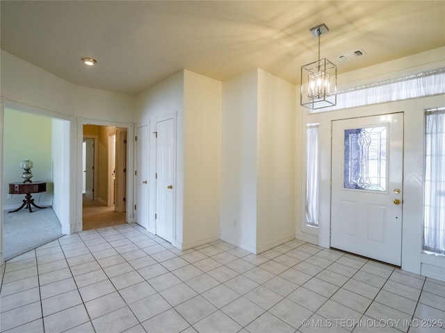 entrance foyer featuring a notable chandelier, light tile patterned flooring, and visible vents