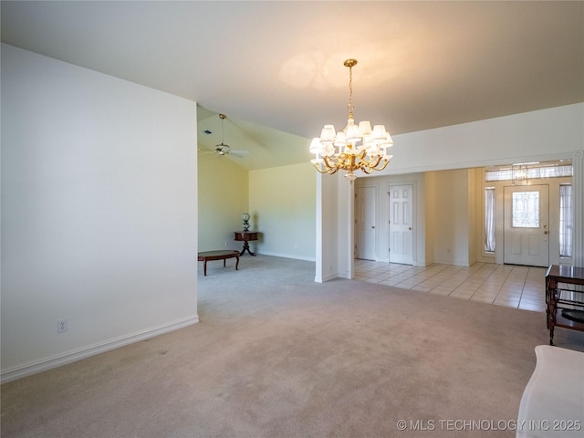 empty room featuring lofted ceiling, an inviting chandelier, light tile patterned floors, baseboards, and light colored carpet