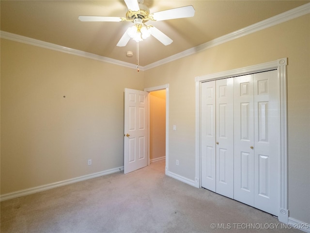 unfurnished bedroom with light carpet, a ceiling fan, a closet, crown molding, and baseboards