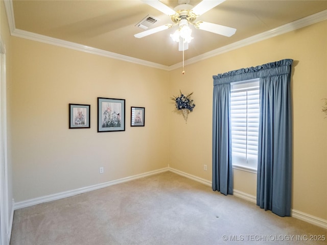 spare room with a ceiling fan, baseboards, visible vents, ornamental molding, and carpet flooring