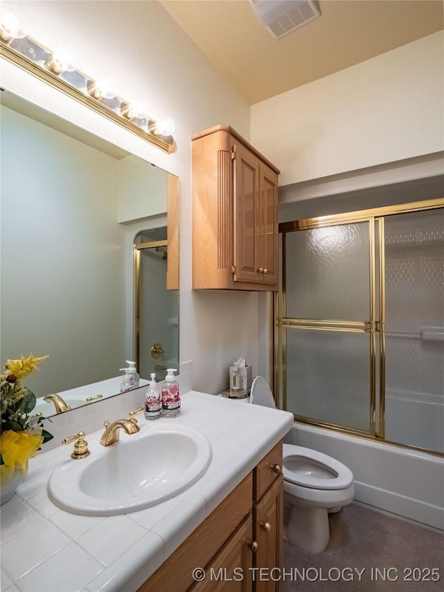 bathroom with visible vents, combined bath / shower with glass door, toilet, and vanity