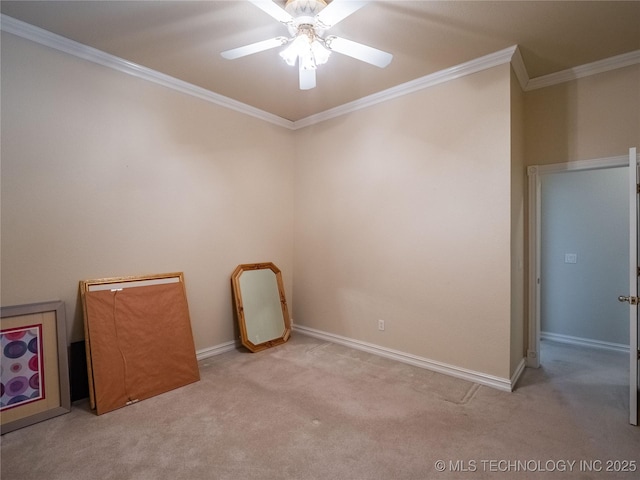 carpeted empty room featuring a ceiling fan, baseboards, and ornamental molding