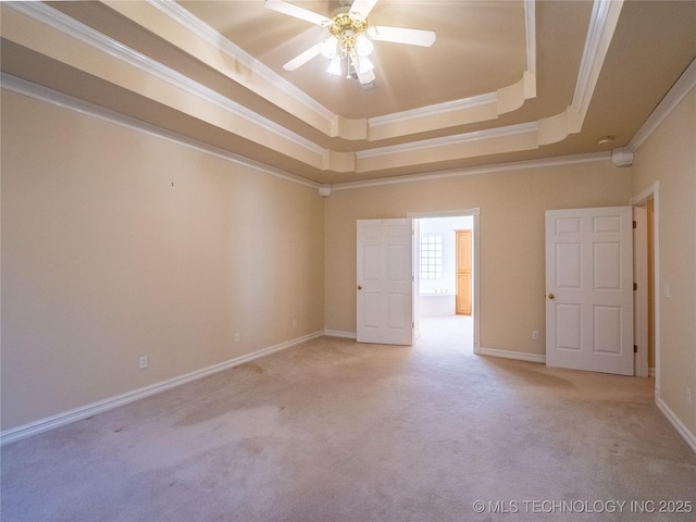 unfurnished room featuring light colored carpet, crown molding, a raised ceiling, and baseboards