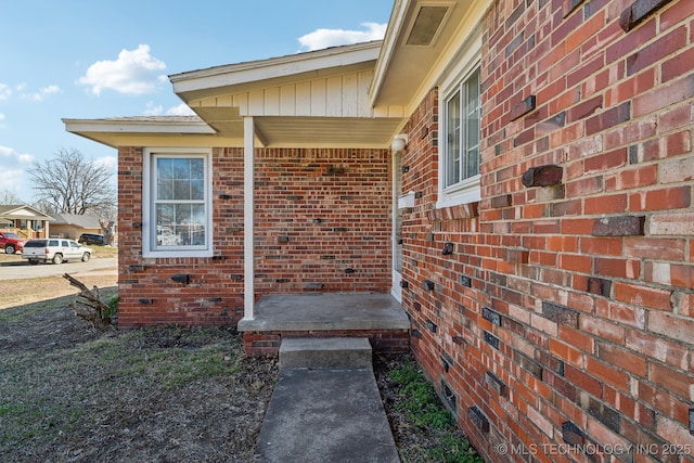 doorway to property with brick siding