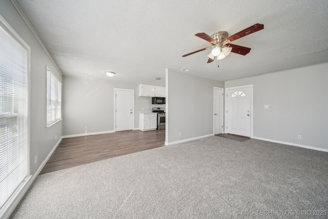 8930 E Marshall St, Tulsa, OK 74115 - unfurnished living room with baseboards, carpet, a ceiling fan, and a textured ceiling