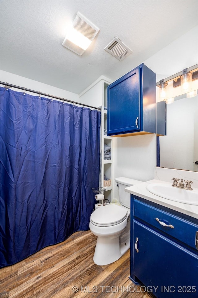 1522 Burney Cemetary, Calera, OK 74730 - full bathroom with vanity, toilet, a textured ceiling, visible vents, and wood finished floors