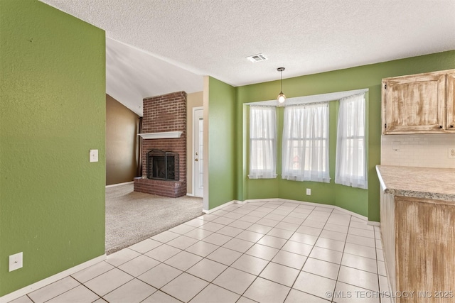 interior space featuring visible vents, light carpet, a fireplace, light countertops, and light tile patterned floors