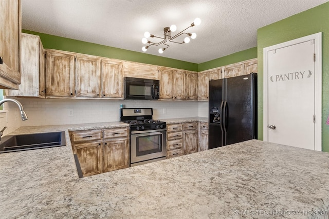 kitchen featuring tasteful backsplash, light countertops, a notable chandelier, black appliances, and a sink