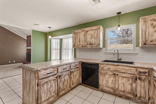 kitchen featuring visible vents, a peninsula, a sink, dishwasher, and a brick fireplace