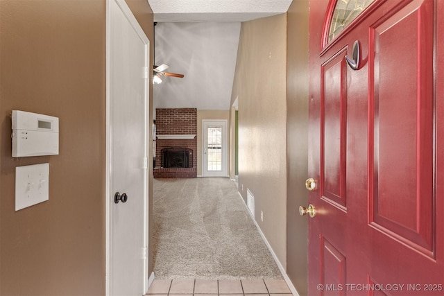 corridor featuring light tile patterned floors, baseboards, visible vents, lofted ceiling, and light colored carpet