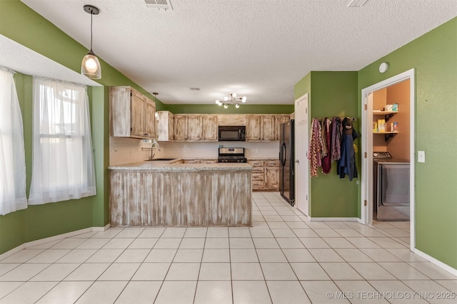 kitchen featuring a peninsula, washer / clothes dryer, a sink, black appliances, and light countertops