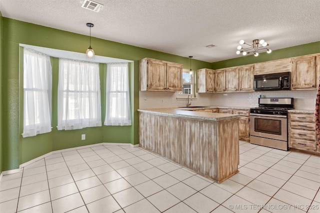 kitchen with stainless steel gas range oven, visible vents, black microwave, light countertops, and light tile patterned flooring