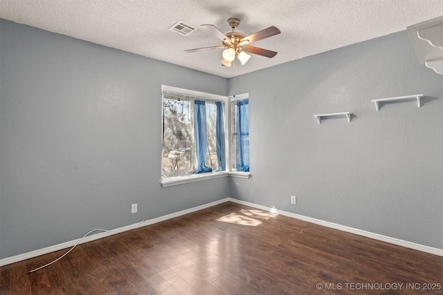 spare room with visible vents, baseboards, and wood finished floors