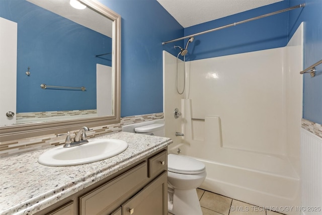 bathroom featuring toilet, vanity, shower / bathtub combination, tile patterned floors, and a textured ceiling