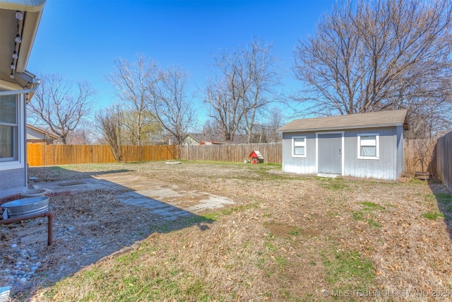 view of yard with a storage unit, an outdoor structure, and a fenced backyard