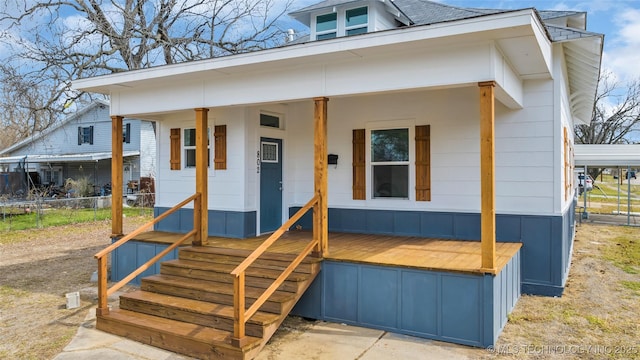 view of front of home with a porch and fence