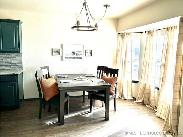 dining room featuring wood finished floors and an inviting chandelier