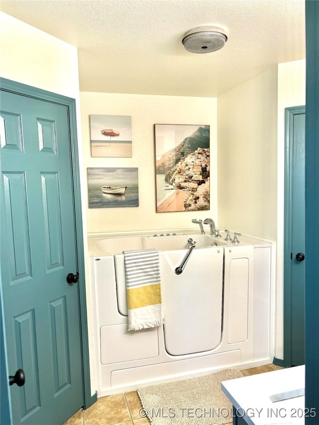 bathroom featuring tile patterned floors and a textured ceiling