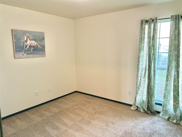 carpeted spare room with baseboards