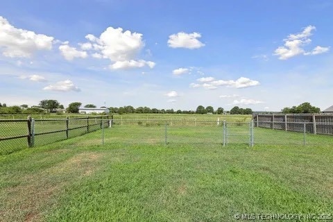 view of yard with fence and a rural view