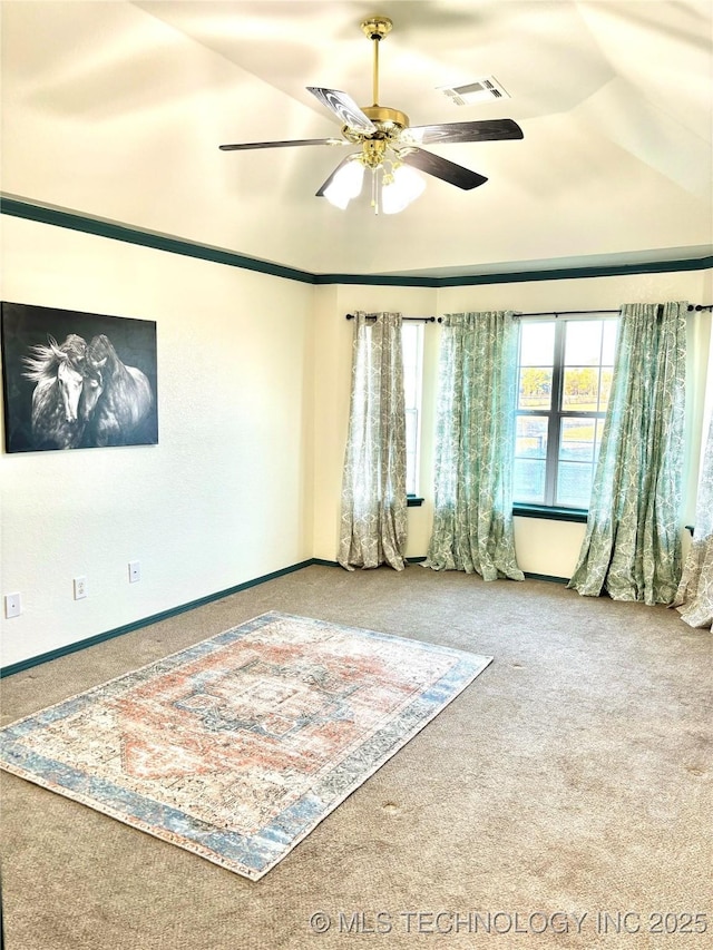 unfurnished room featuring baseboards, visible vents, a ceiling fan, and carpet