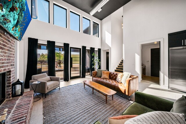7701 S 21st St, Broken Arrow, OK 74011 - living area featuring a towering ceiling, a fireplace, and stairs