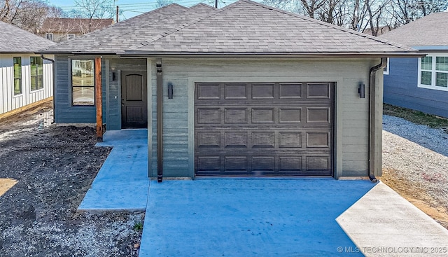 exterior space featuring a garage, driveway, and a shingled roof