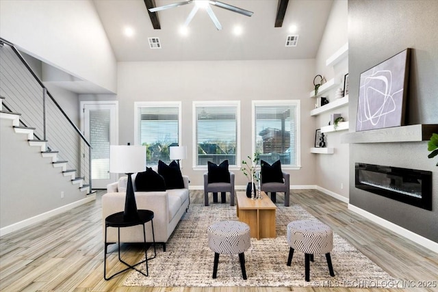 living area with visible vents, light wood-style flooring, and a fireplace