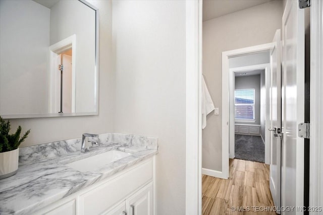 bathroom featuring baseboards, wood finished floors, and vanity