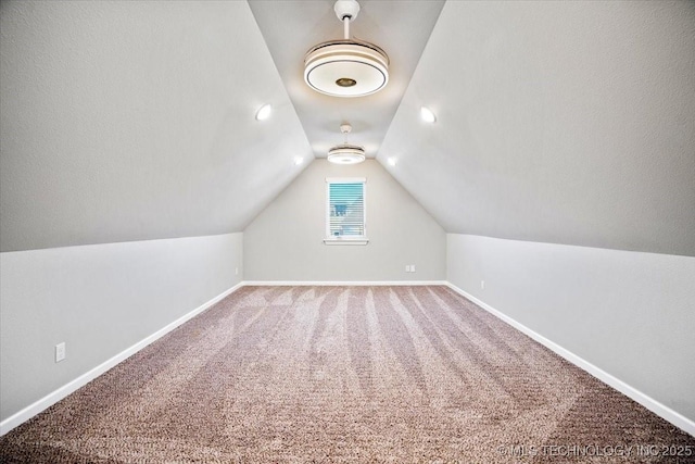 additional living space featuring baseboards, carpet flooring, and vaulted ceiling