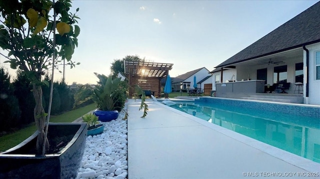 pool at dusk with an outdoor pool, a pergola, and a patio