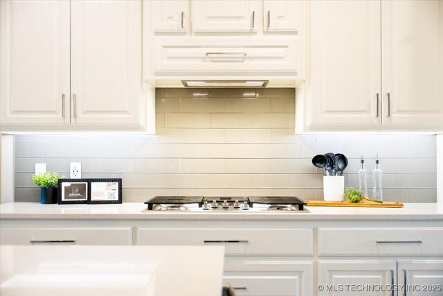 kitchen with light countertops, white cabinets, tasteful backsplash, and stainless steel gas cooktop