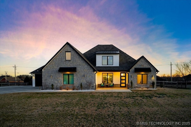 modern farmhouse style home with a patio, concrete driveway, a front lawn, and fence