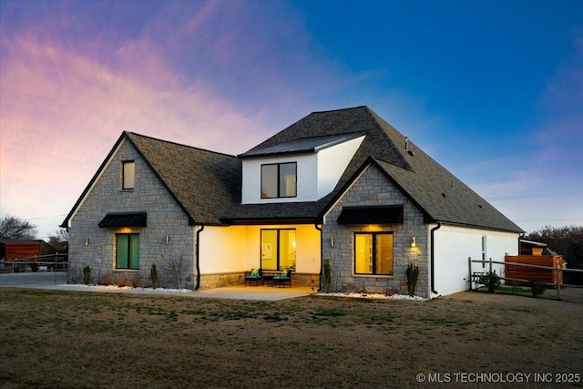 view of front of property with a shingled roof, a front yard, fence, and a patio area