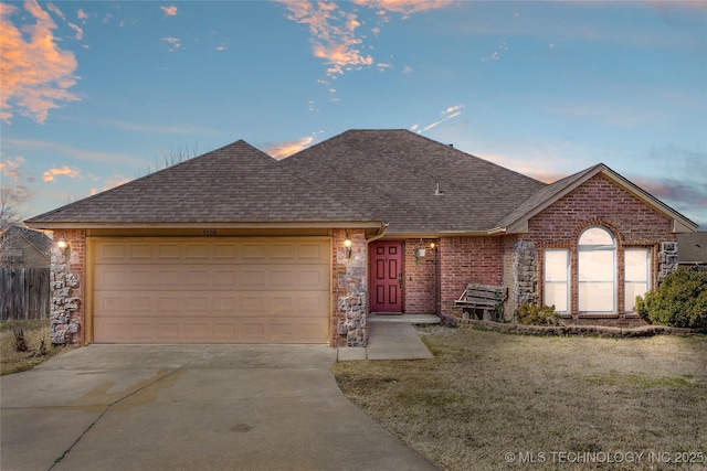 ranch-style home featuring brick siding, a front lawn, concrete driveway, roof with shingles, and an attached garage