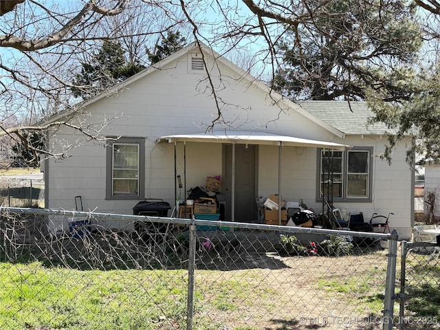 back of property with a lawn, roof with shingles, and fence