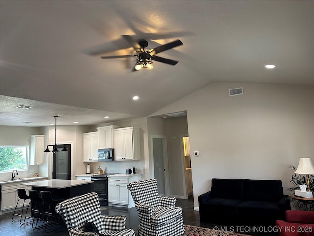 kitchen with electric range, a kitchen island, visible vents, and light countertops