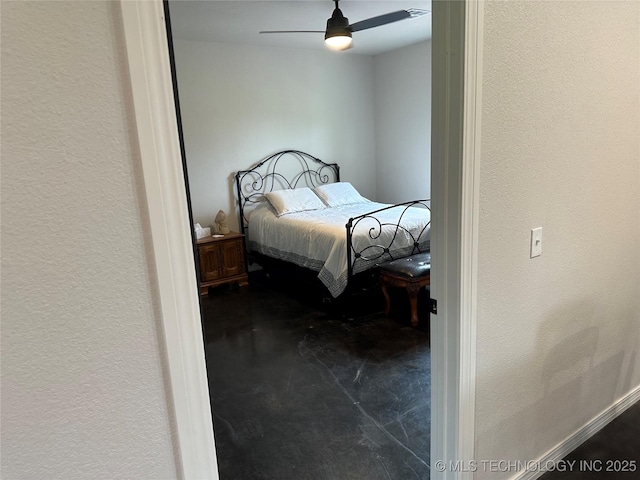 bedroom with finished concrete flooring, a textured wall, and ceiling fan