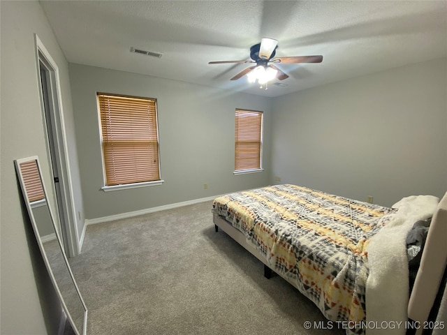 carpeted bedroom featuring visible vents, a textured ceiling, a ceiling fan, and baseboards