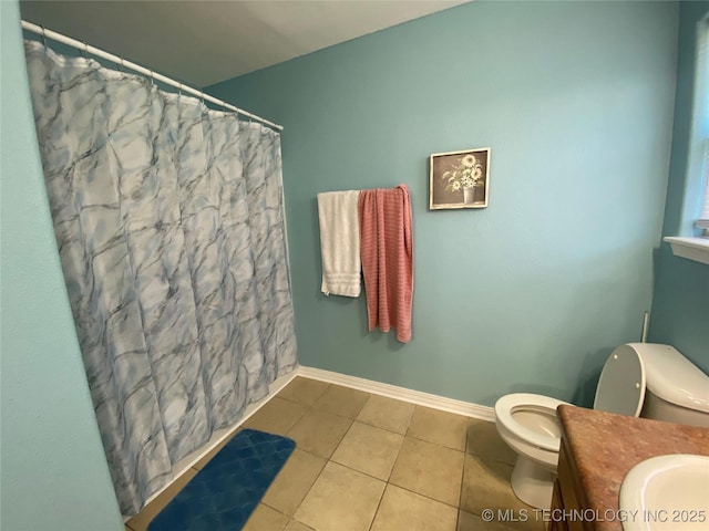 full bathroom featuring toilet, curtained shower, tile patterned flooring, baseboards, and vanity