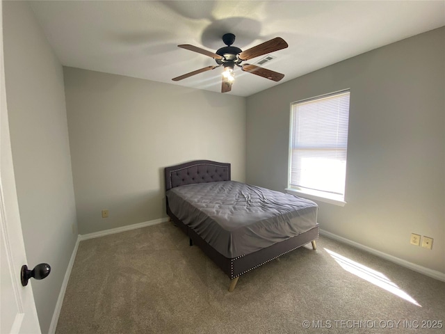 carpeted bedroom featuring visible vents, baseboards, and a ceiling fan