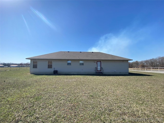 back of house featuring entry steps and a yard