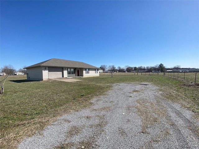 view of front of home with a front yard, fence, and a garage