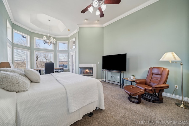 bedroom with crown molding, baseboards, carpet flooring, a high ceiling, and a glass covered fireplace